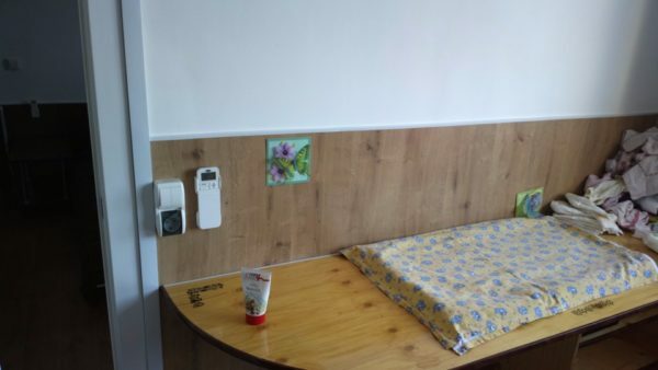 Kinderzimmer. Die Wände sind mit laminierter Platte zu einer Höhe von 1,2 Metern bedeckt. Die Beschichtung schützt vor Spritzern von Getreide oder Fruchtpüree und Spielzeug von den Schlägen. Kinder mit Kindern ...