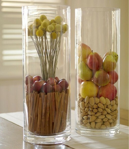 Helle Früchte und Nüsse ursprünglichen Blick auf hohe transparente Blumenvase