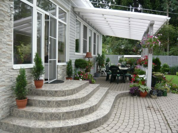 Patio near the main entrance facade is decorated profitable cottage