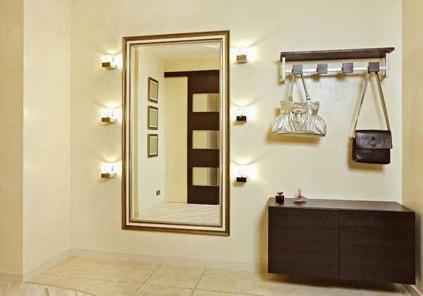 Lamps in the hallway are placed in such a way that they do not dazzle a person and illuminate the space above the mirror