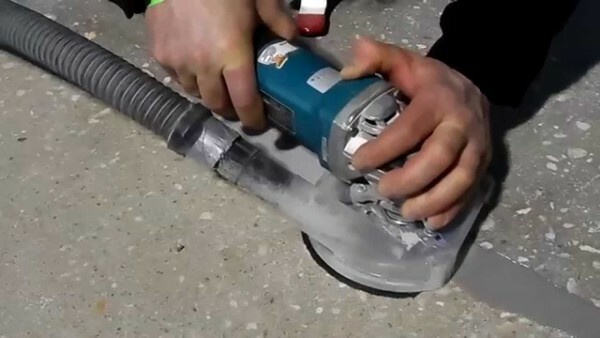 Grinding the concrete surface using angle grinders with their hands