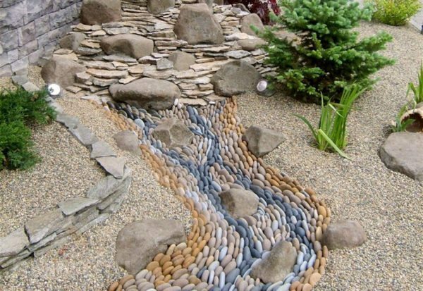 Strom trockener Steine, die in eine Richtung gelegt worden sind, wie ein richtiger Fluss mit fließendem Wasser