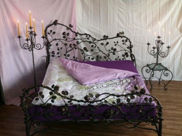 pat de fier forjat cu o tăblie frumoasă poate servi nu numai un loc de odihnă și de somn, dar, de asemenea, un decor real al dormitorului