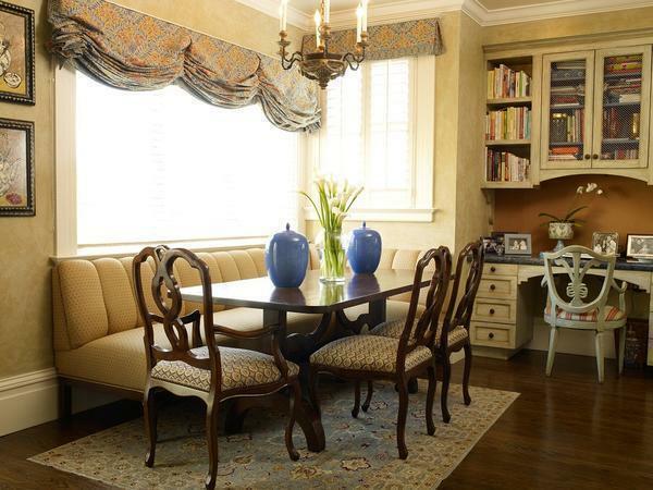 Wooden chairs with graceful bends perfectly complement the table, located in the classical living room