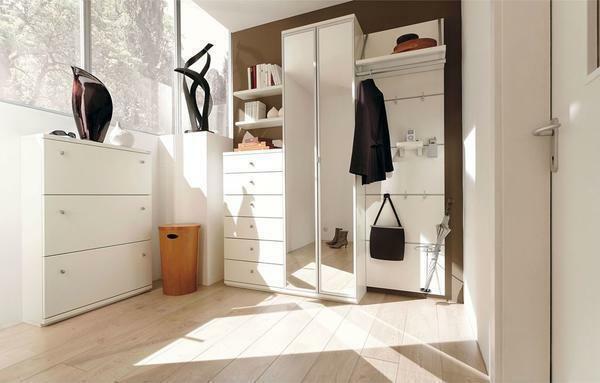 A small hallway in which bright walls and floor from a white parquet board, looks spacious and original