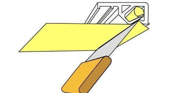 Baguette de plafond de tension est retiré avec une spatule avec manche en bois