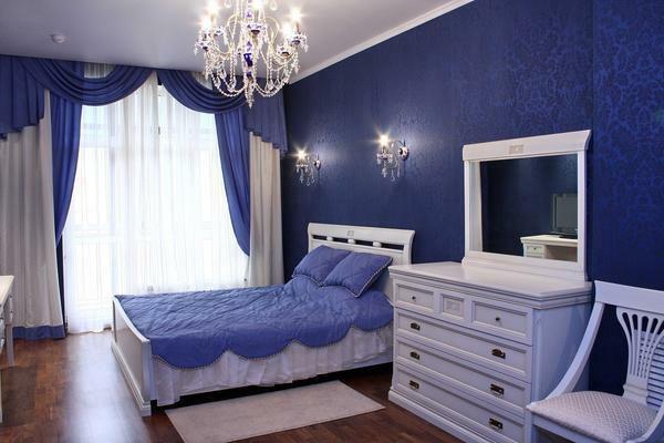 Balta klasiskā mēbeles izceļas pret zils sienām, lai telpa nešķiet vienmuļa un garlaicīga