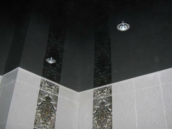 Glossy black ceiling in the bathroom is combined with a tile of any color