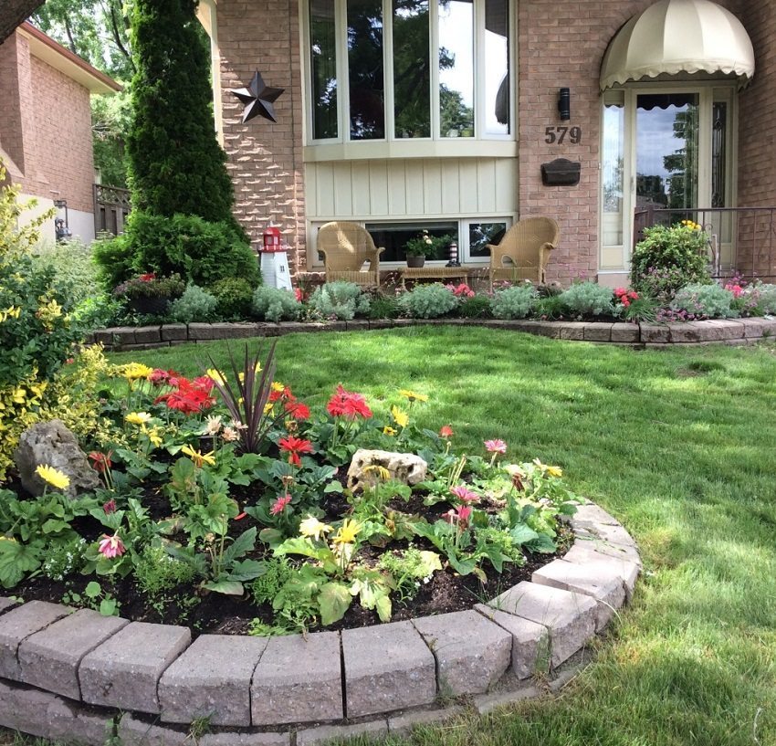 A flower bed with a brick border decorates the yard