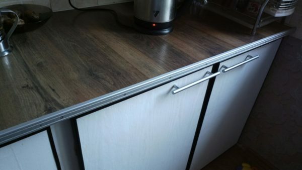 Work surface fitted kitchen. Here we have used the same scheme that and on the desktop - laying boards on the plywood countertop. Because of constant contact with water seams slightly swelled.
