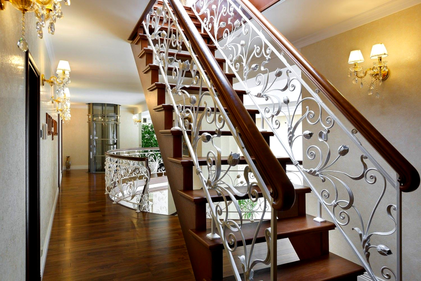 Kované zábradlí s dřevěným madlem je nejžádanějším schodišťovým zábradlím