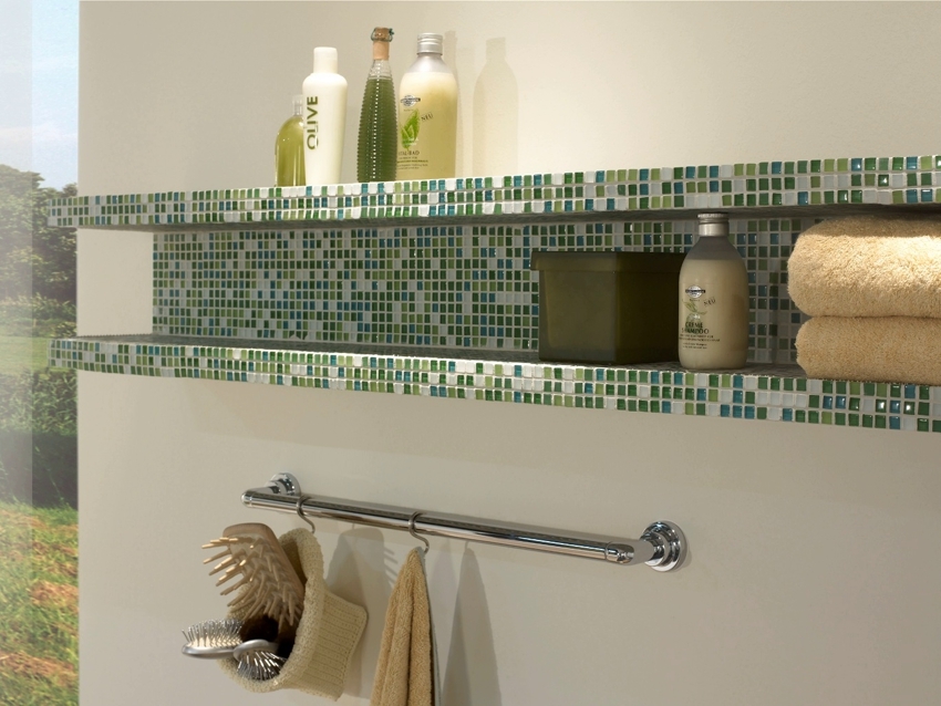 The shelf in the bathroom is tiled with mosaics