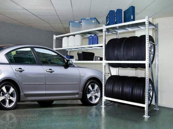 Garasje perforert metallhyller på stativer for lagring av forbruksvarer og bil-