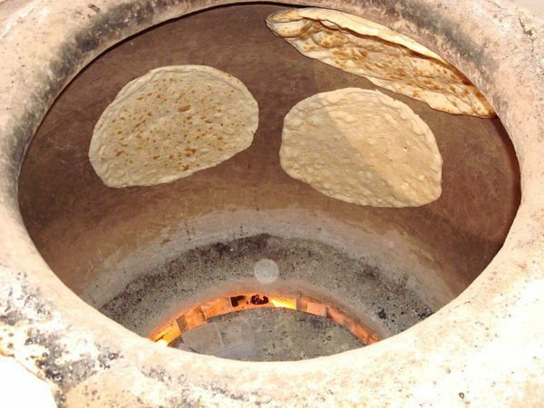 Baking bread on the walls of the tandoor.