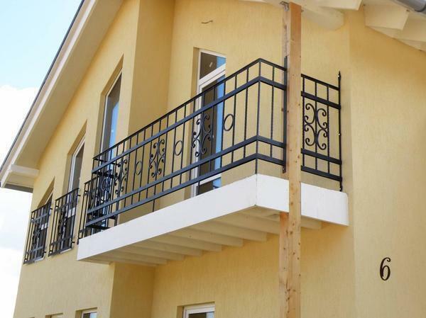 Za balkona, napravljen u klasičnom stilu, dobro prilagođene metalne ograde s krivotvorenim elementima