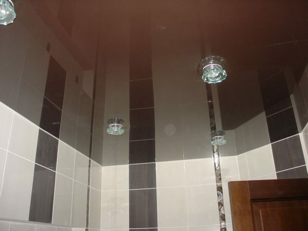 Glossy film ceiling will make your bathroom visually higher and will not allow you to fill the neighbors.