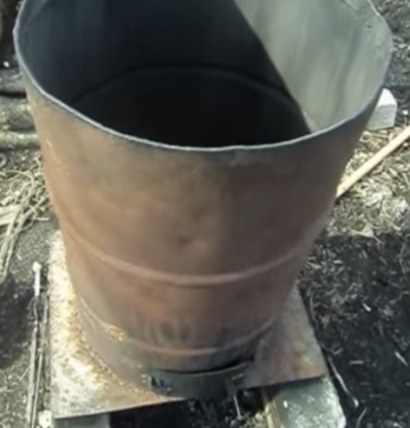 Barrel with cut top welded to a metal sheet.
