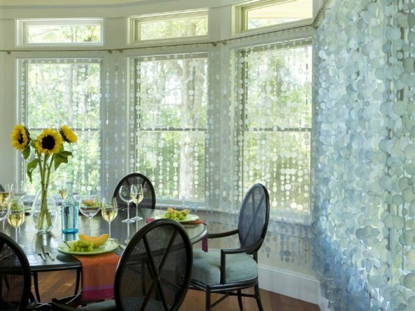 Unusual curtains of plastic circles give the room a freshness