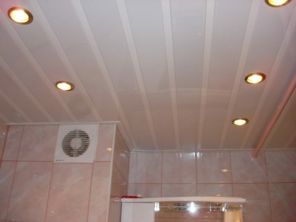 Spuščen strop iz plastičnih plošč s skritimi lučmi.