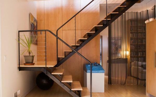 Perfectly in the interior of a modern room will fit a stylish metal staircase with wooden steps