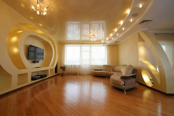 A great option for a large room will be a combination of a yellow glossy ceiling with beige wallpaper