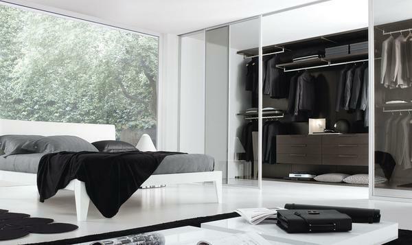 Im Schlafzimmer im Stil von hallo-Tech, großer Ankleide, ausgestattet mit Glasschiebetüren aus