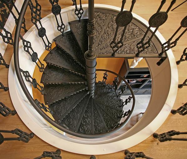 For a living room in a classic style, a forged spiral staircase with an interesting design