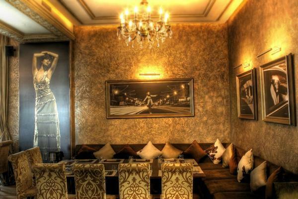 Furniture of classic, dark colors is so self-sufficient that it can be safely placed next to the walls, decorated with yellow wallpaper