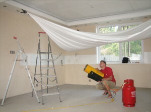 Repairs stretch ceiling with his hands