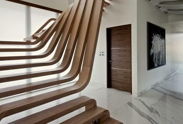 Trappor med böjda eleganta linjer passar perfekt i det inre, utformad i stil med högteknologiska eller modern