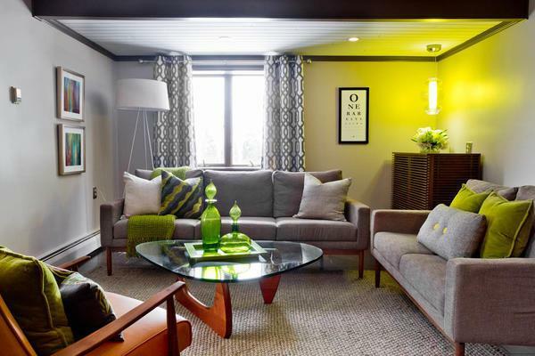 Svijetlo naglasak u gostinjskoj sobi sivih elemenata može biti žute ili zelene nijanse dekor