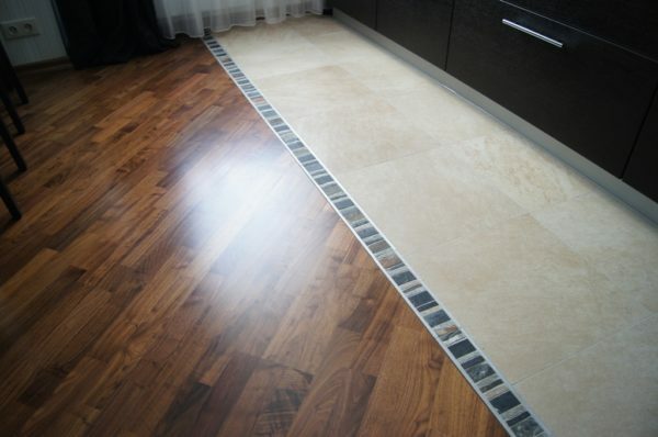 Kombinerat golv i köket i närheten av arbetsområdet läggs hållbara och vattentåliga plattor.