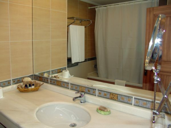 Ogledalo nad umivalnikom ploščadi širi prostor majhno kopalnico.