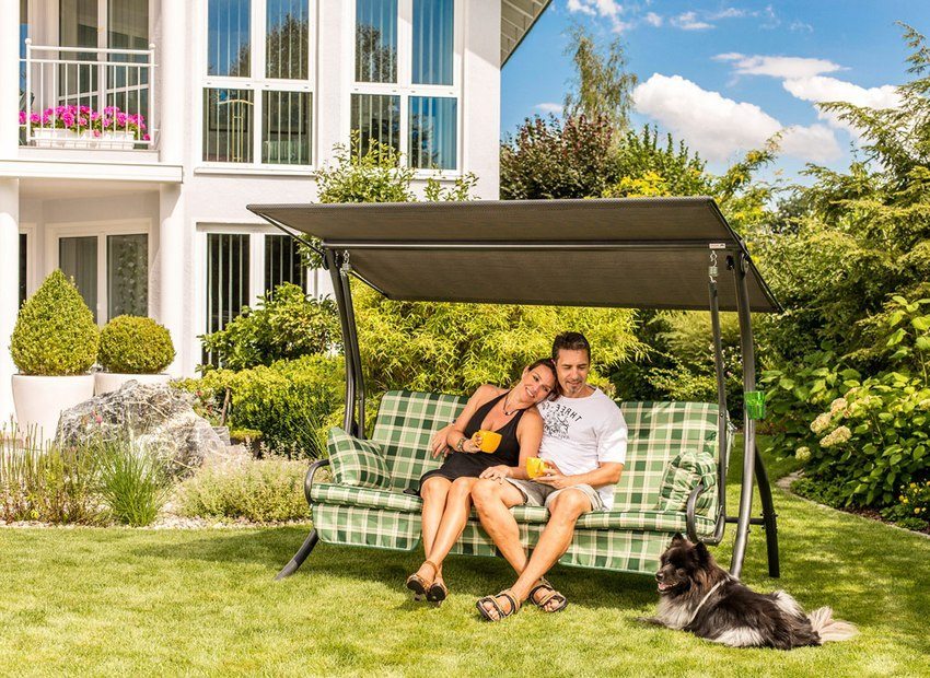 Metal swing stue type med en topp som ligger i bakgården til et privat hus